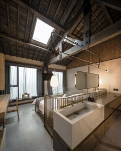 Modern industrial-style bedroom with wooden beams and skylight.