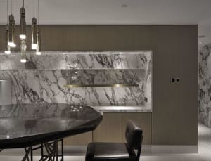 A modern kitchen featuring a marble countertop and backsplash.