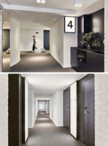 Floor-to-ceiling view of a modern corridor featuring a white brick wall, gray carpeted floor, black doors, and a black kitche
