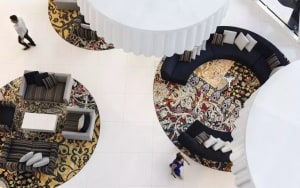 Modern hotel reception area featuring carpet and cushions