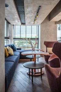 Modern living room featuring wooden flooring, concrete walls, and marble accents.