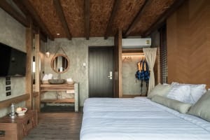 Modern industrial hotel room with concrete walls and wooden accents