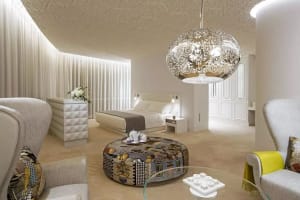 A modern bedroom suite featuring a white fabric headboard and floor-length curtains.