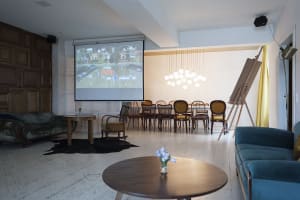 A modern living room with a mix of blue and brown color schemes, featuring wooden furniture and a large screen showing a bowl