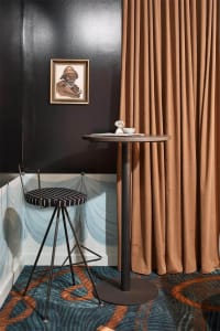 A sleek, modern bar area featuring a metal curtain and industrial design elements.