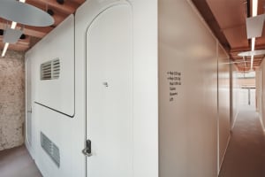Office interior with modern, metal-clad walls and white doors.