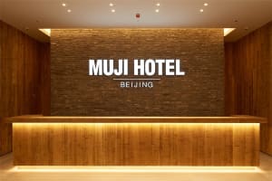 Modern wooden reception desk in the Muji Hotel Beijing lobby.