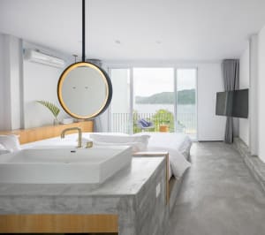 Modern residential bedroom featuring concrete, glass, and wood elements.