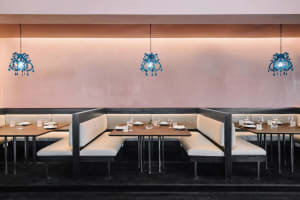 A restaurant interior with booth seating and blue chandelier lighting.