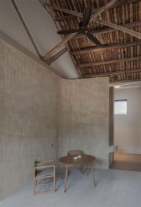 A minimalist residential interior featuring concrete and wooden materials.