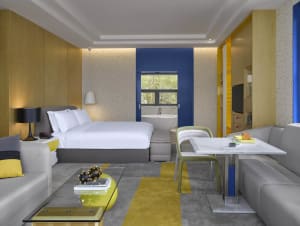 A modern hotel room with concrete walls and a minimalist design.