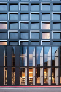 A modern building with glass windows and reflections in the city.
