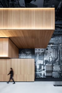 A modern office lobby with wooden walls and an artistic mural on the wall.