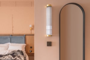 A modern bedroom showcasing metallic arch lighting and a sleek mirror.