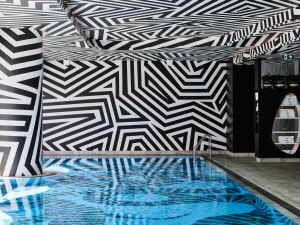 Swimming pool interior with black and white geometric patterns on the walls and ceiling.