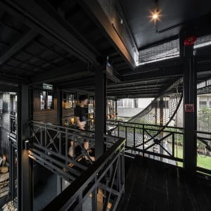 A modern coffee shop with black wooden panels and an industrial design aesthetic.