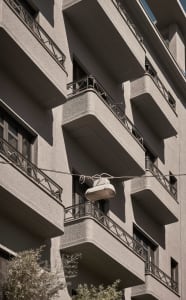 Concrete building with balconies and streetlight hanging from wire