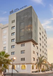 Modern hotel building with concrete and glass exterior.