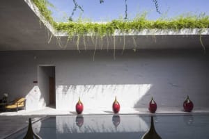 A modern pool with concrete walls and glass features.