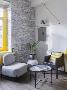 Modern, industrial-styled living room with exposed concrete and brick walls, featuring minimalist furniture.