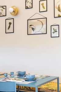 Minimalist dining room featuring ceramic tableware on a blue table.