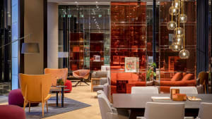 A modern restaurant interior with wooden furniture, leather accents, and glass walls.