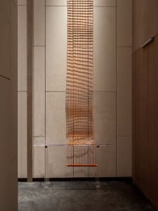 A wall-mounted acrylic table designed with metal wire for an industrial aesthetic.