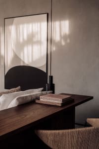 Modern minimalist living space with a textured paper-covered worktable and a large abstract artwork featuring geometric shape