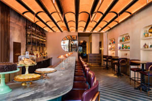 Modern restaurant interior with a concrete bar counter and high-top seating.