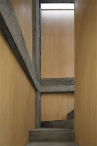 Concrete staircase with wooden walls and floor.