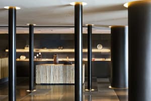 Modern industrial-style restaurant bar with metallic columns and wood panels