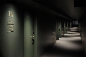 Modern metal hotel corridor with numbered doors and professional lighting