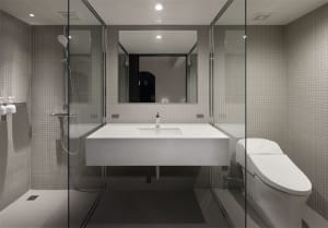 A modern bathroom with minimalist design and ceramic tile walls and floor.