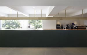 A modern cafe interior with a wooden counter and minimalistic design.