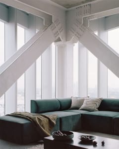 Modern minimalistic living room interior with a large, comfortable concrete couch accompanied by sleek, minimalist furnishing
