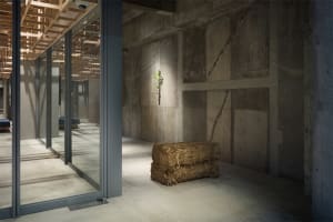 Concrete walls and floor with hay bales in an office space.