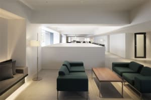 A modern office interior featuring a minimalist design with a concrete wall and floor.
