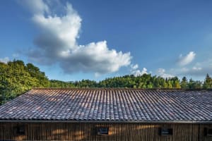 A close-up view of a traditional roof featuring overlapping terracotta tiles.