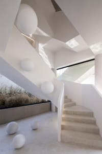 Modern room with concrete floor, glass walls, and geometric shapes.