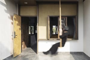 Blurred motion of a person swinging in a modern living room with natural wood elements.