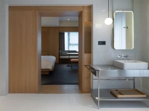 A modern bathroom with a floating vanity, white porcelain tiles, and a minimalist design.