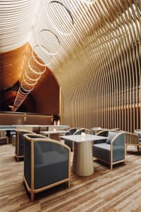 A modern restaurant bar featuring a textured wood interior design.