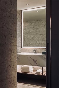Modern bathroom with marble fixtures and a large mirror.