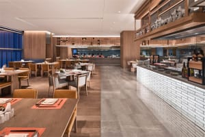 Industrial-themed restaurant buffet area with concrete, wood, and glass materials.