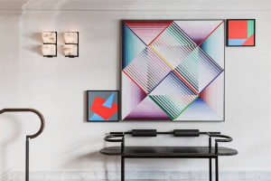 A modern lobby space featuring a wall installation with a multicolor geometric abstract pattern.