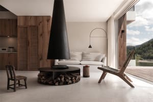 A minimalist living room with concrete walls and floors, featuring a modern fireplace and lounge furniture.