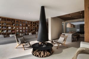 A modern living room featuring a concrete fireplace and built-in bookshelves.