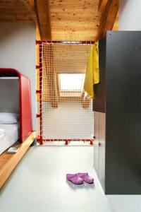A modern bedroom featuring wooden elements and a net gate.