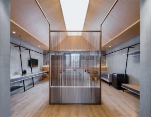 Modern industrial office interior with wood slat wall and concrete floor.