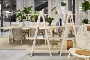 A modern loft office space featuring wooden furniture, concrete flooring, and potted plants.